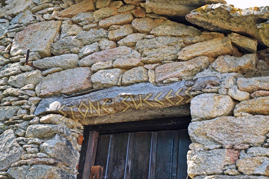 Деревянная балка над дверным проемом каменного дома из бута